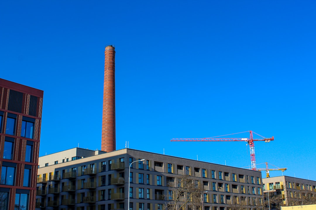 A tall brick building with a crane in the background
