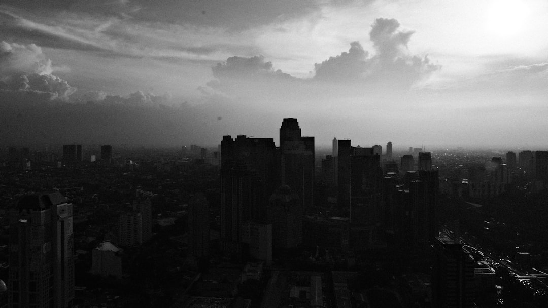 Monochromatic cityscape with dramatic clouds at sunset.