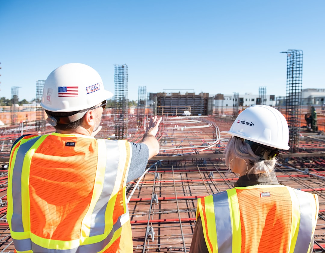 Two construction workers in safety vests at site