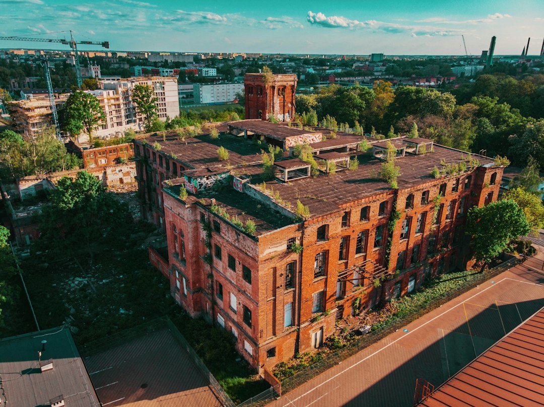 Brown concrete building near green trees during daytime